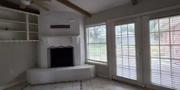 Image 2: Bright living area with large windows and French d