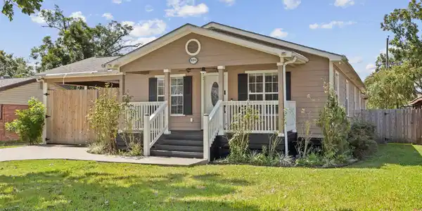 Image 2: Charming front exterior with a welcoming covered p
