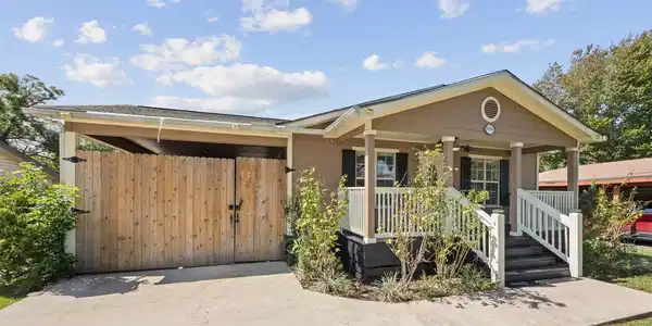 Image 3: Side exterior view featuring the driveway, covered