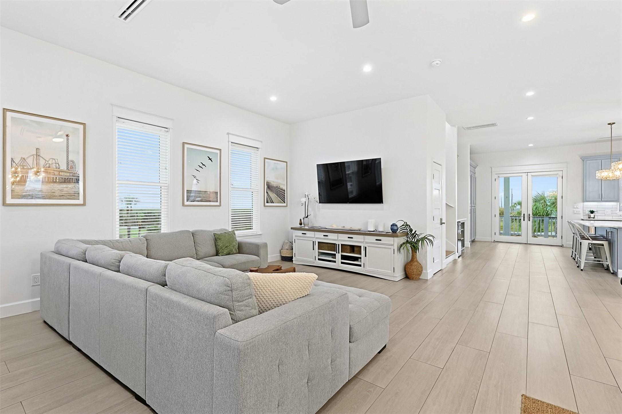 Image 4: Bright living space with large windows, custom bli