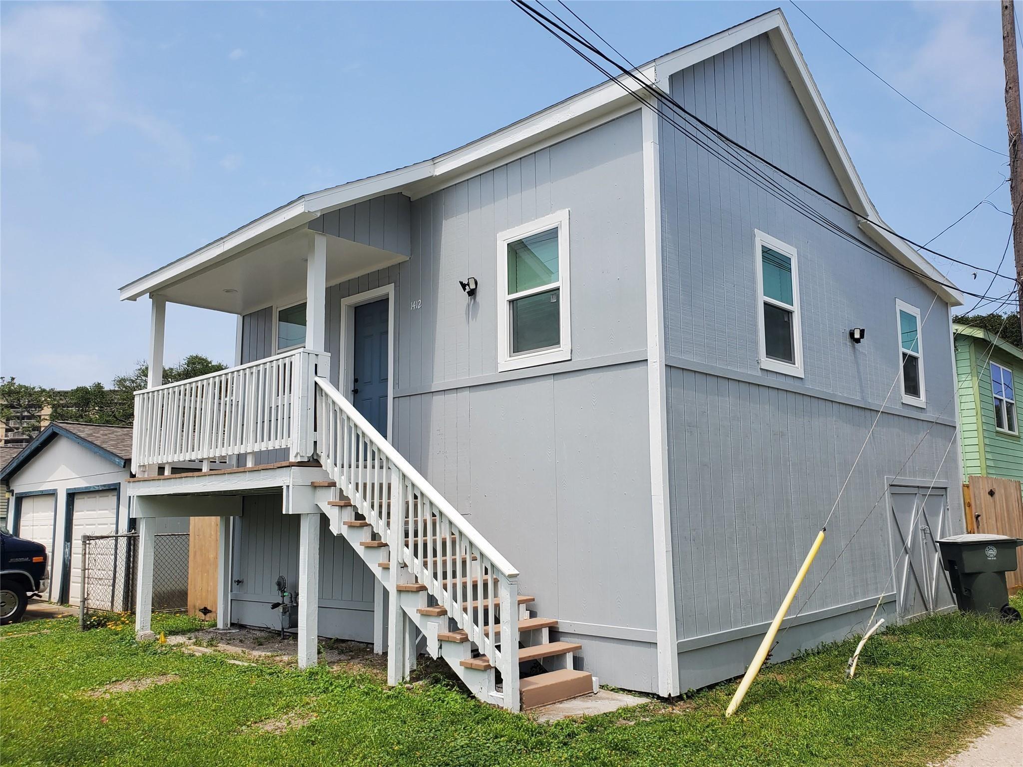 Image 2: This is a raised, gray, two-story home with a cove