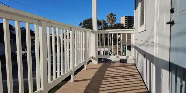 Image 4: This show has a cozy balcony with white railings a
