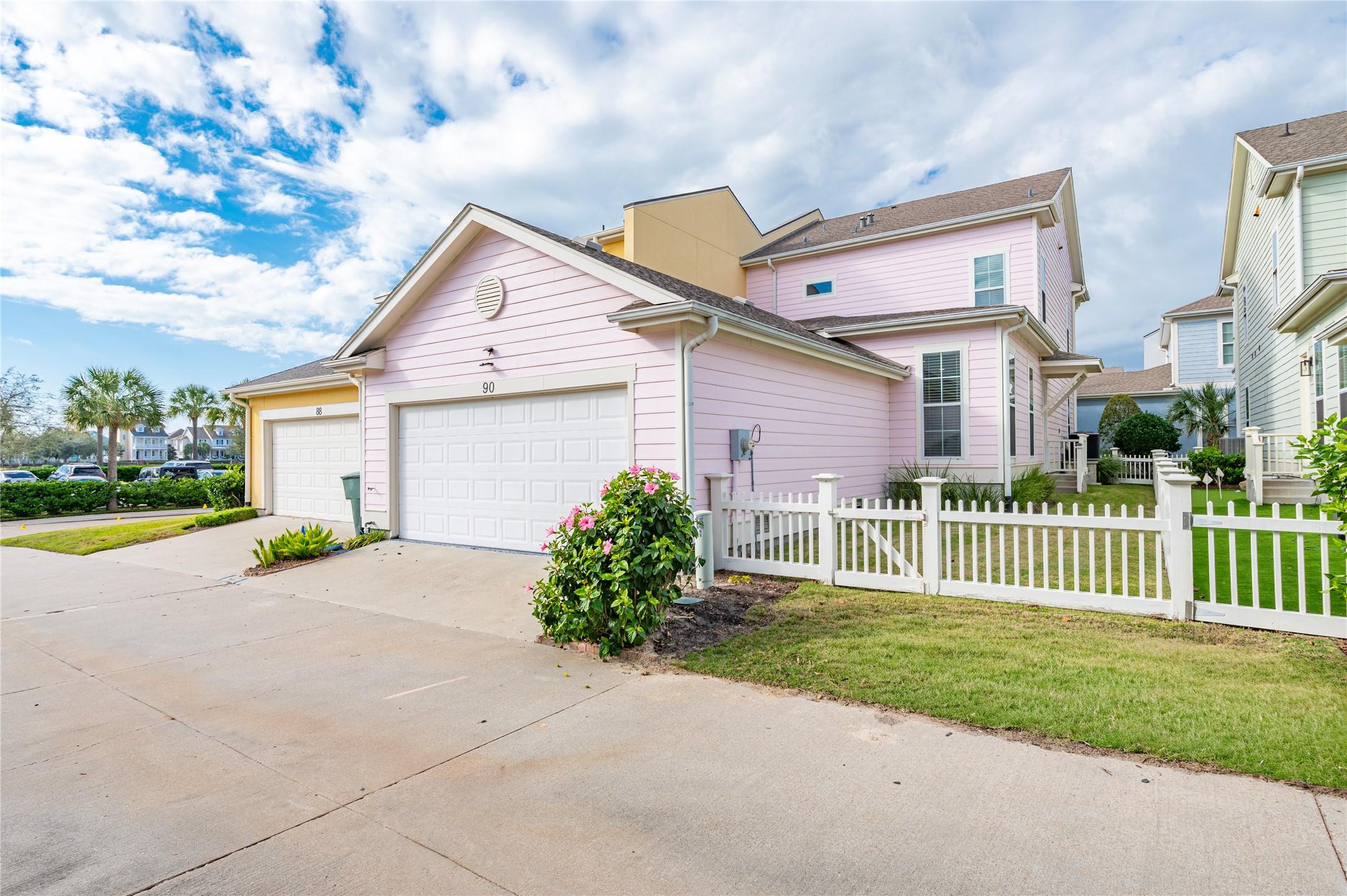 Image 2: It features a side yard with white picket fencing,