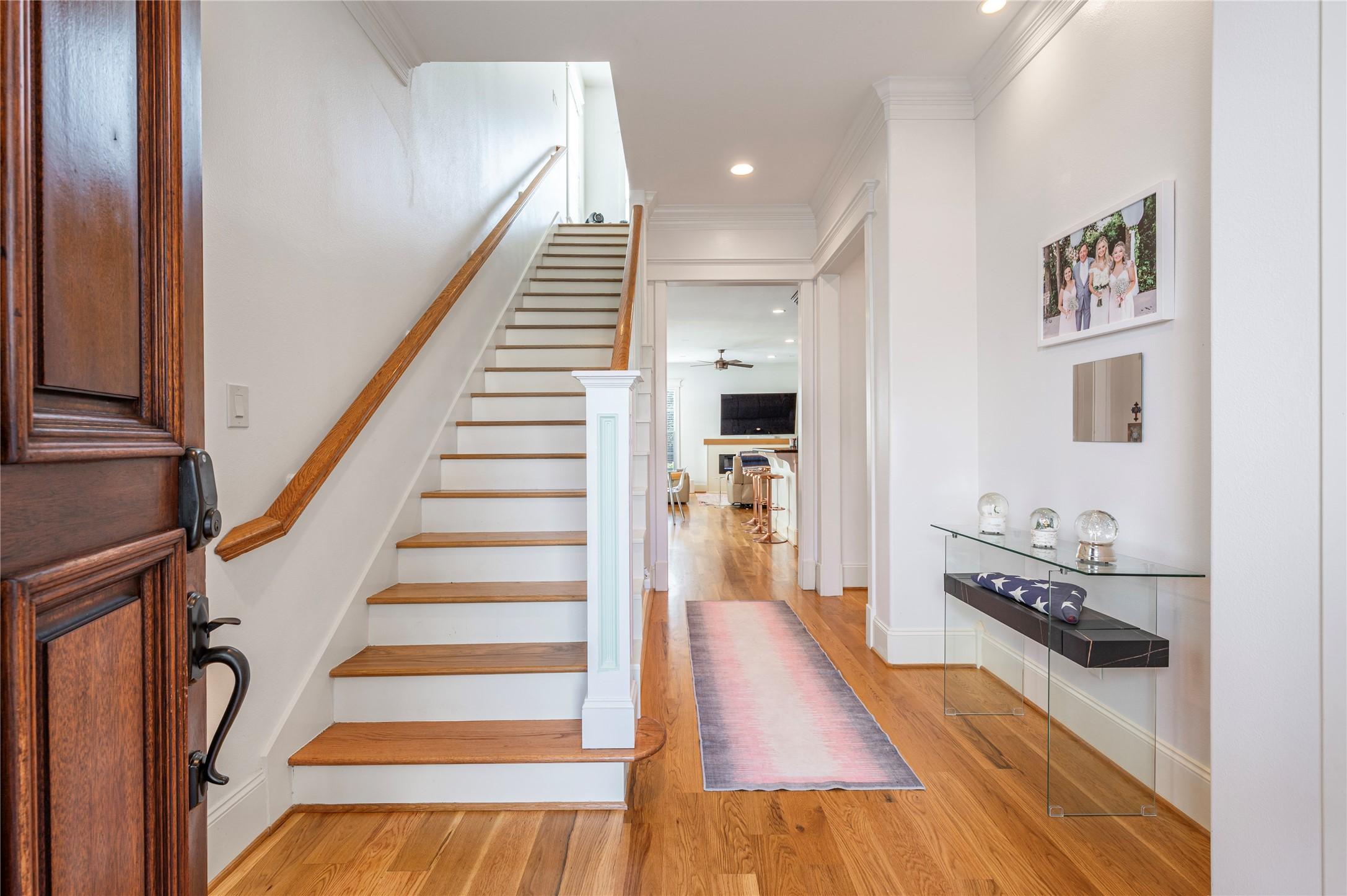Image 4: This welcoming entryway features a wooden staircas