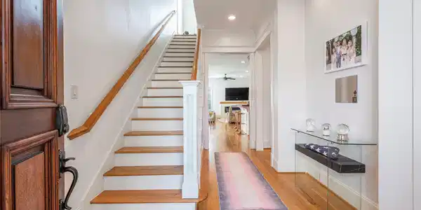 Image 4: This welcoming entryway features a wooden staircas