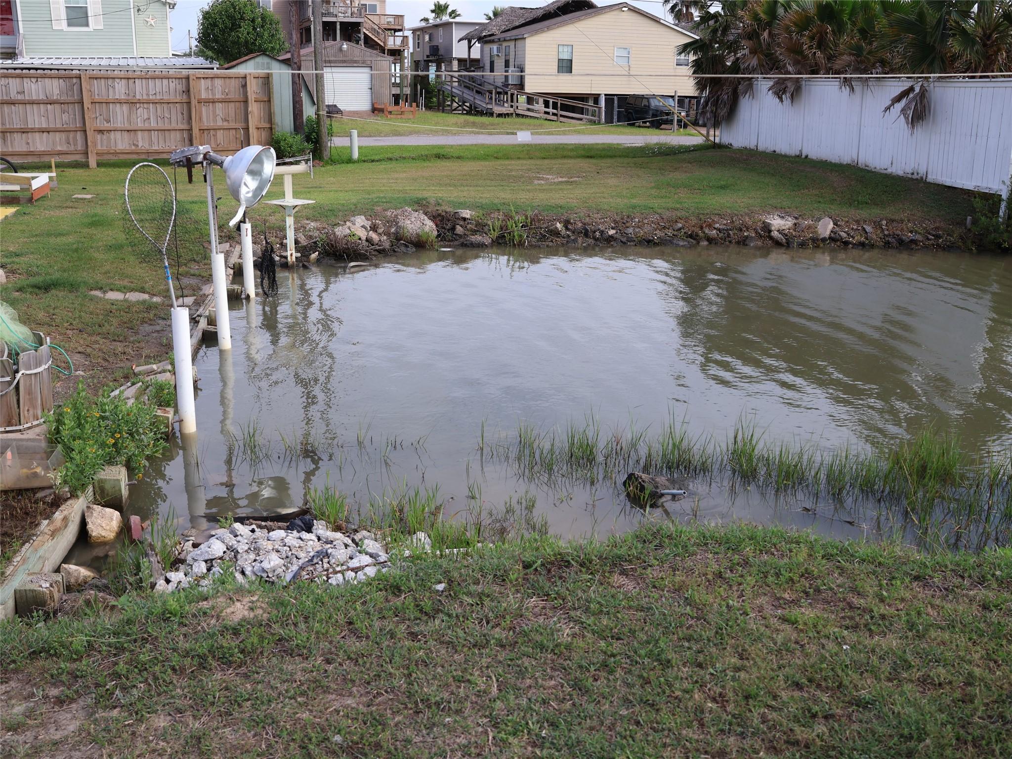 Image 4: This photo shows a backyard with a small waterway,