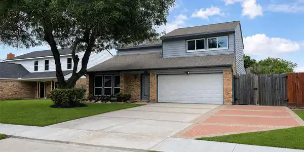 Image 2: Front exterior with two-car garage, extended drive