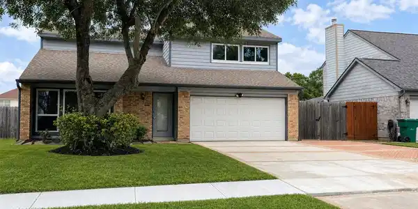 Image 3: Front elevation showing updated siding, brick acce