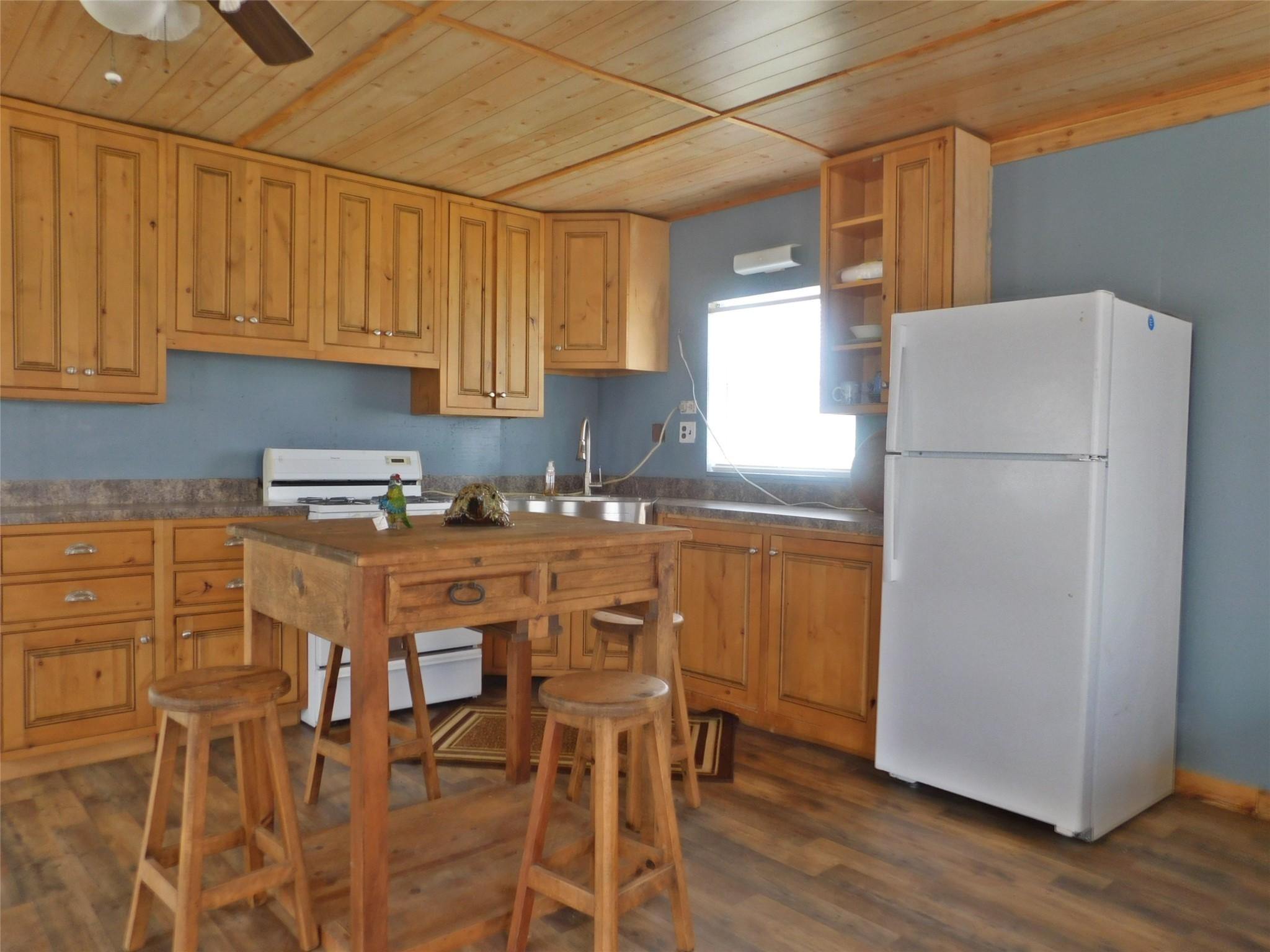Image 4: This cozy kitchen features wooden cabinetry and a