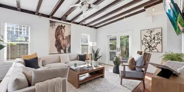 Image 4: Inviting living room featuring exposed wood-beamed