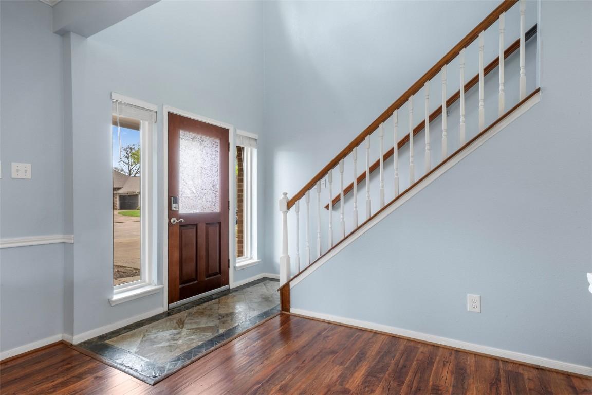 Image 3: Bright entryway with a wooden front door and side