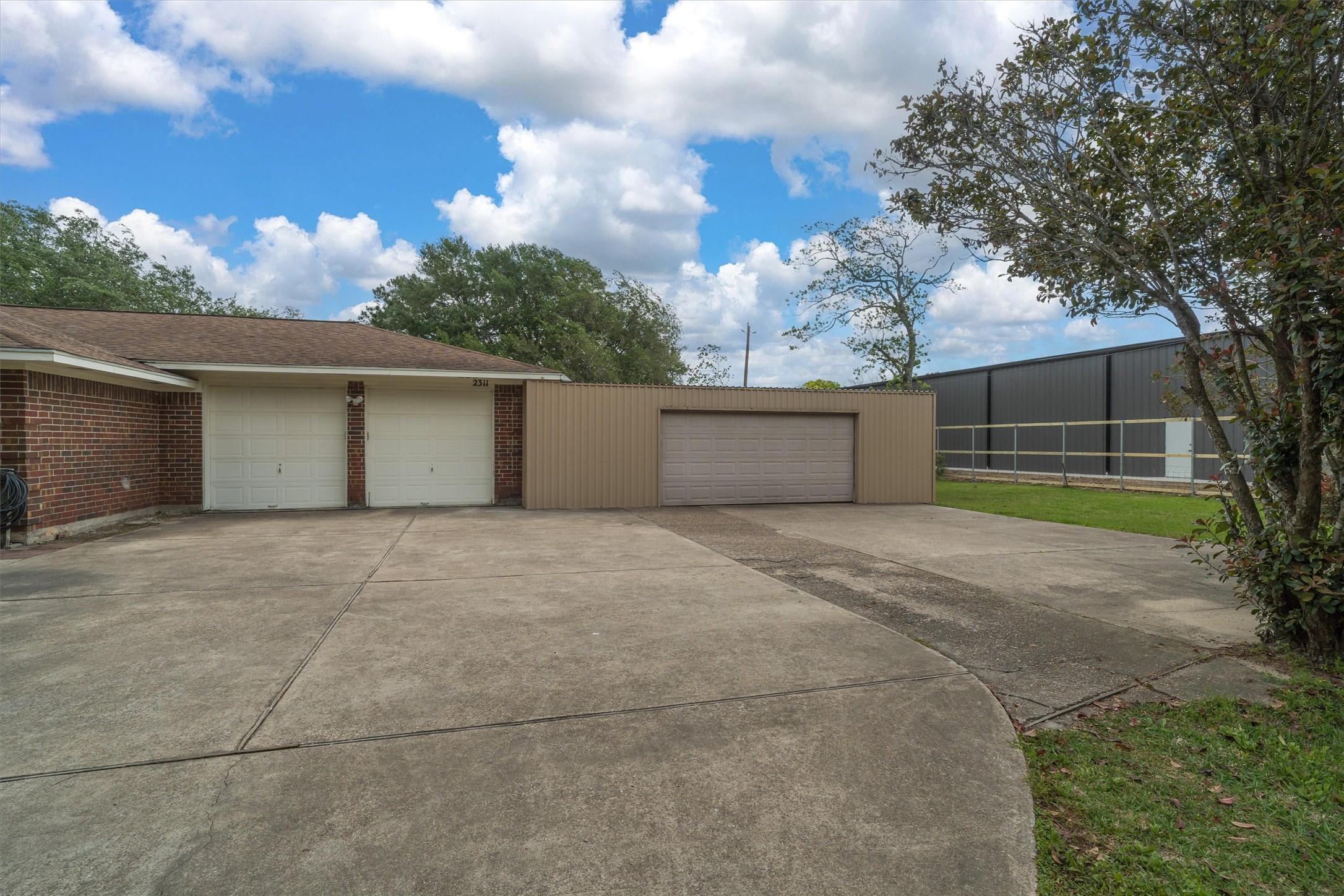 Image 4: Super wide driveway leading to a 2 car garage, in