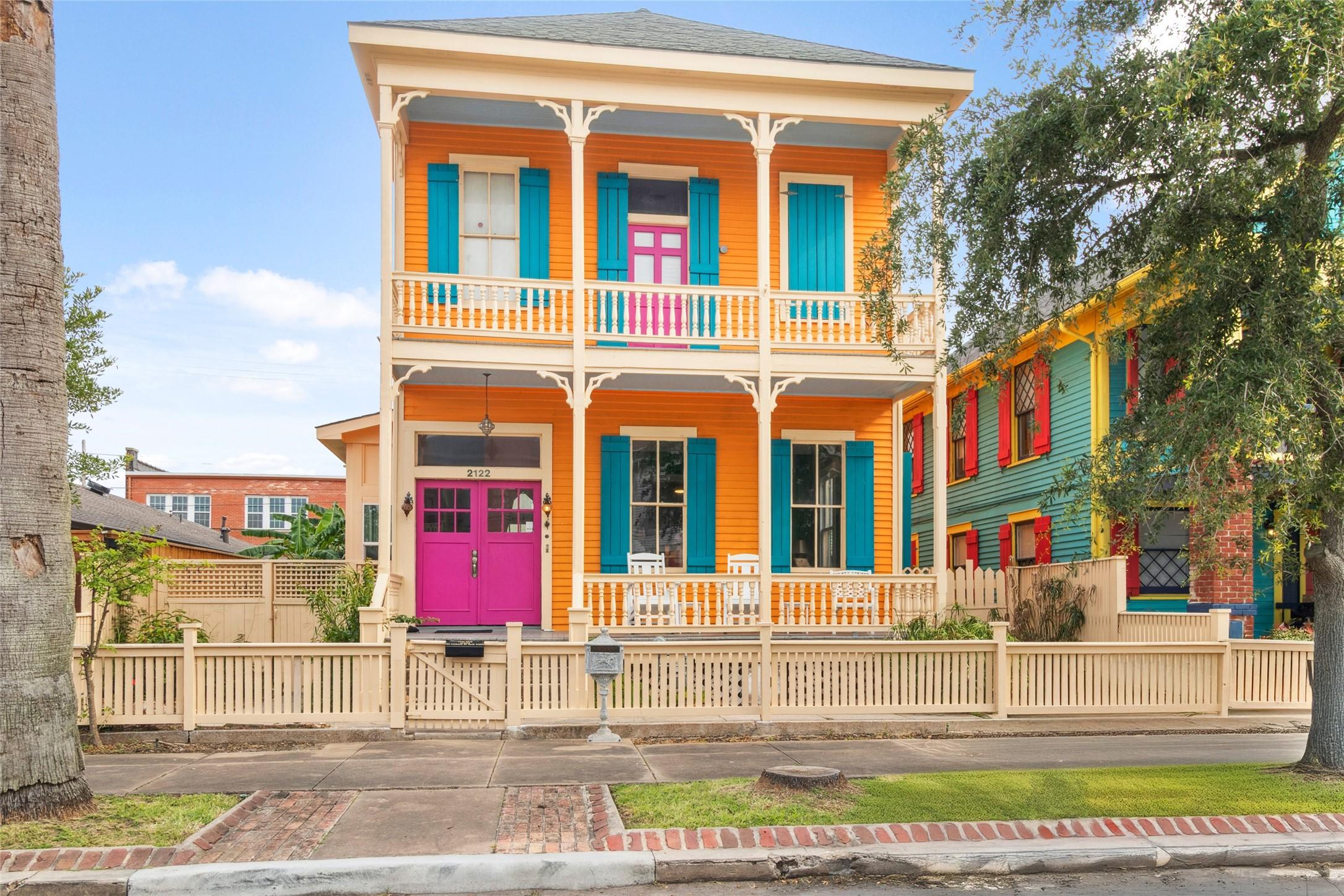 Image 2: This vibrant two-story home features a bold orange