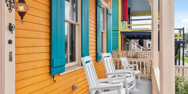 Image 3: This vibrant porch features a bold orange and turq