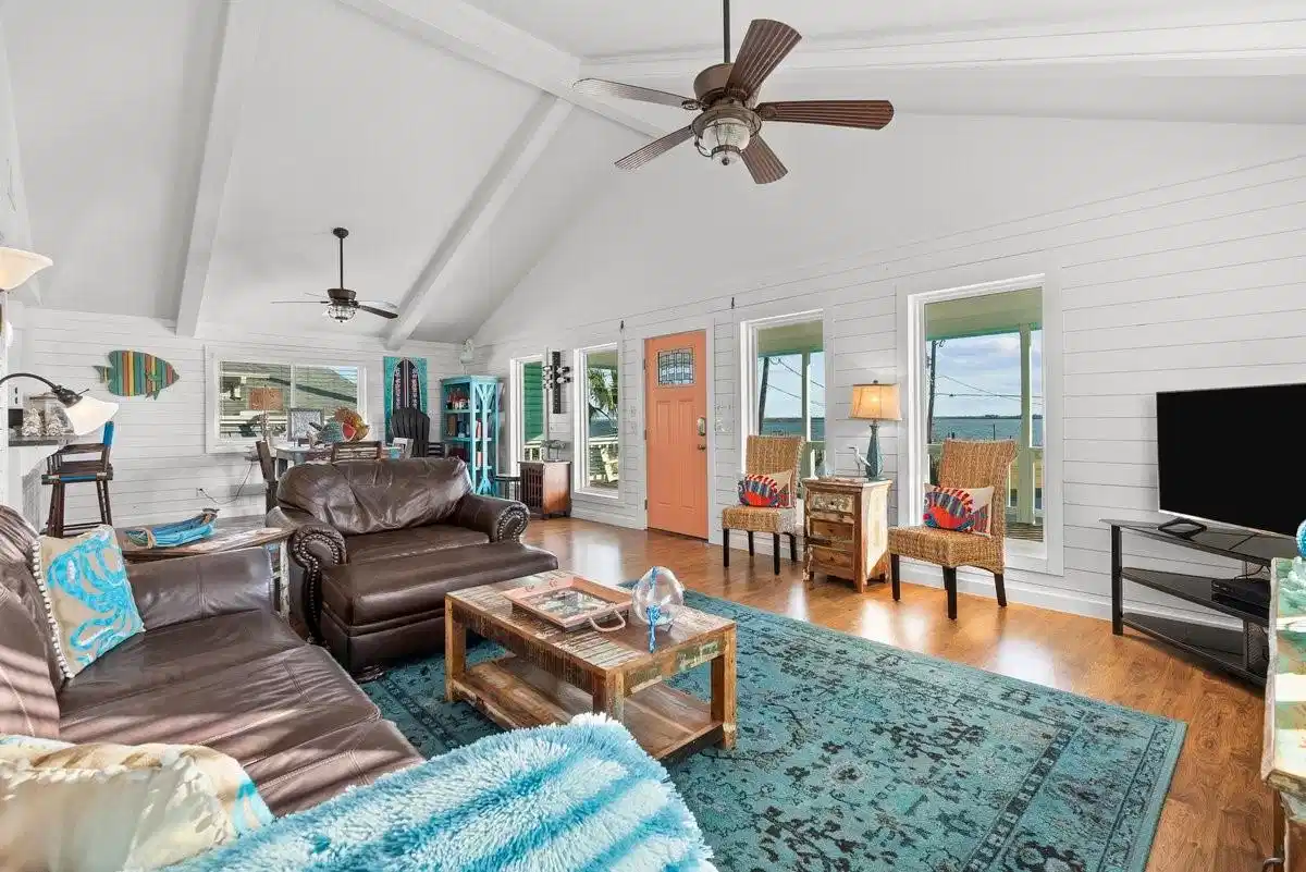 Image 1: This inviting living room features vaulted ceiling