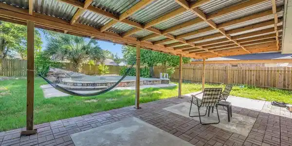 Image 3: Covered back patio overlooking the pool area and f