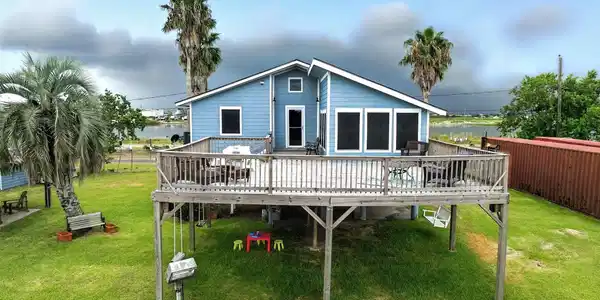 Image 3: View of rear of home with upper level deck and low