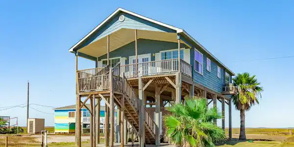Image 2: Welcoming front deck and dual stairway entry lead