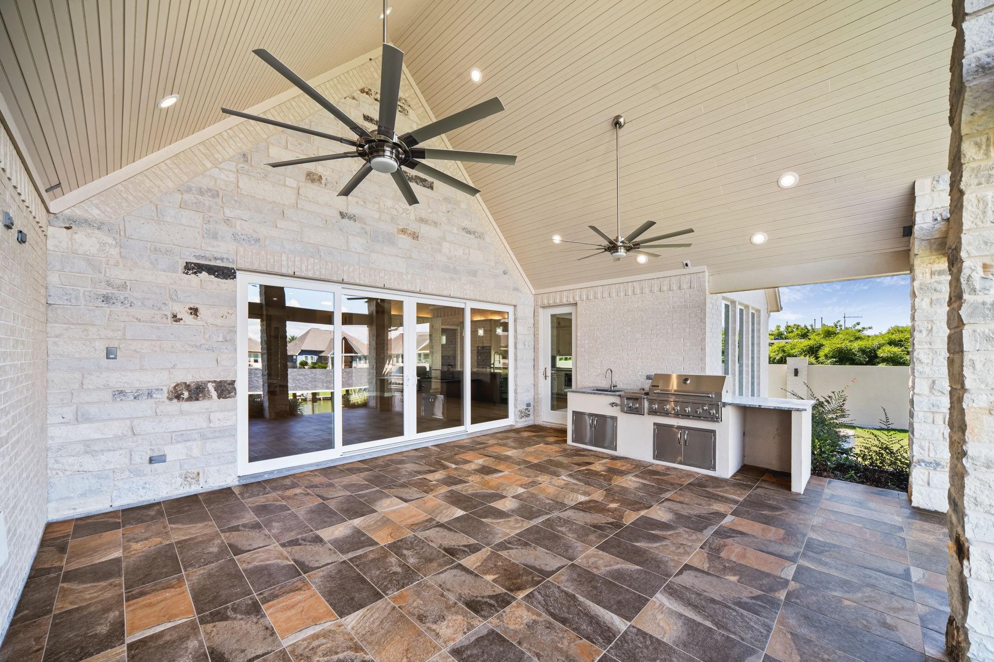 Image 4: Expansive covered patio with ceiling fan, tile flo