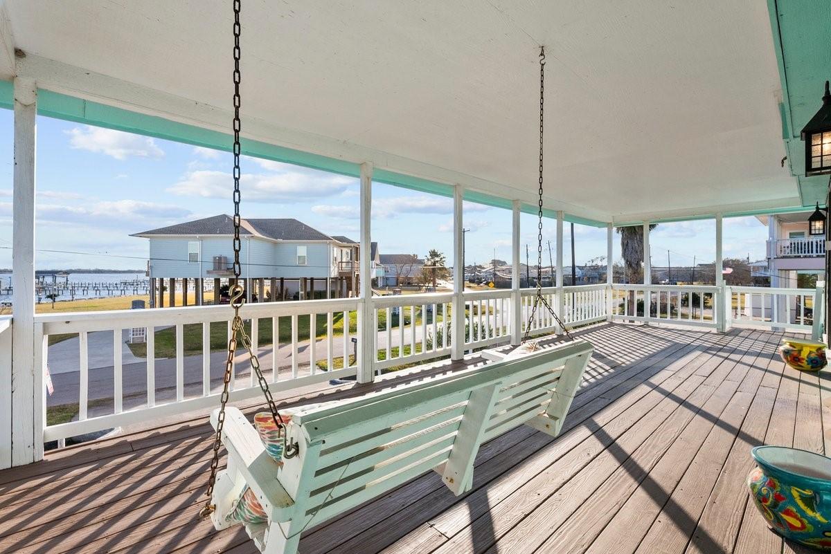Image 3: This spacious covered porch features a wooden swin