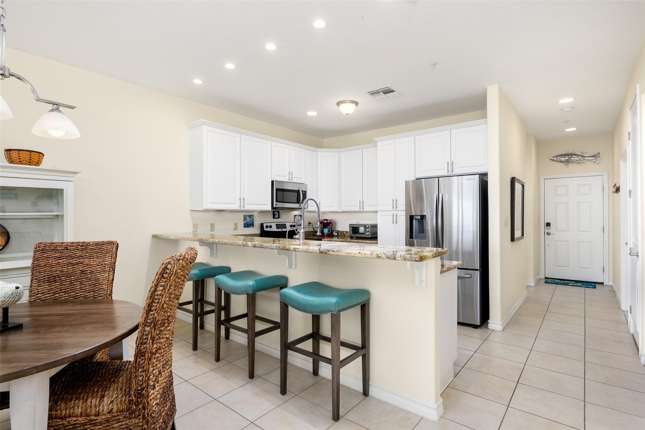 Image 4: Kitchen has granite countertops and refrigerator t