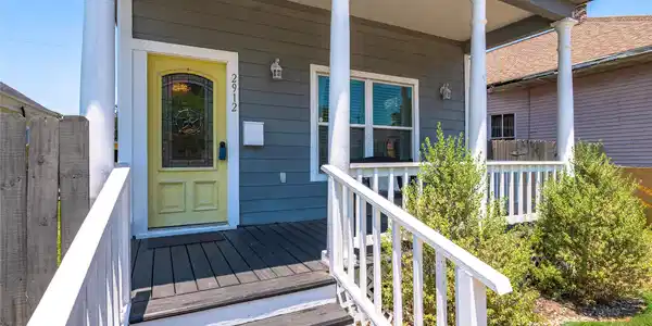 Image 3: Spacious porch area framed in classic white picket