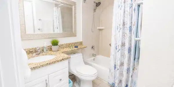Image 4: Charming bathroom with granite countertops, an ele
