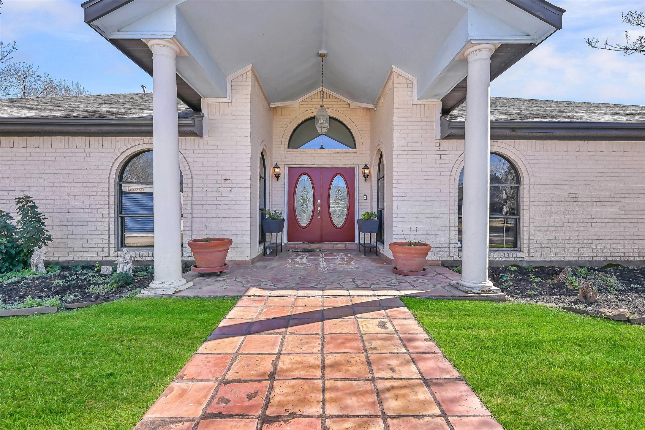 Image 1: A saltillo tile walkway leads to the covered front
