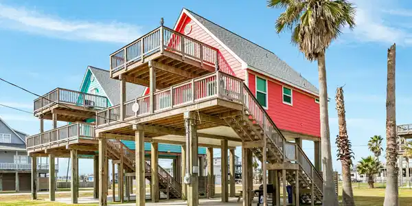 Image 3: Charming elevated beach house with vibrant exterio