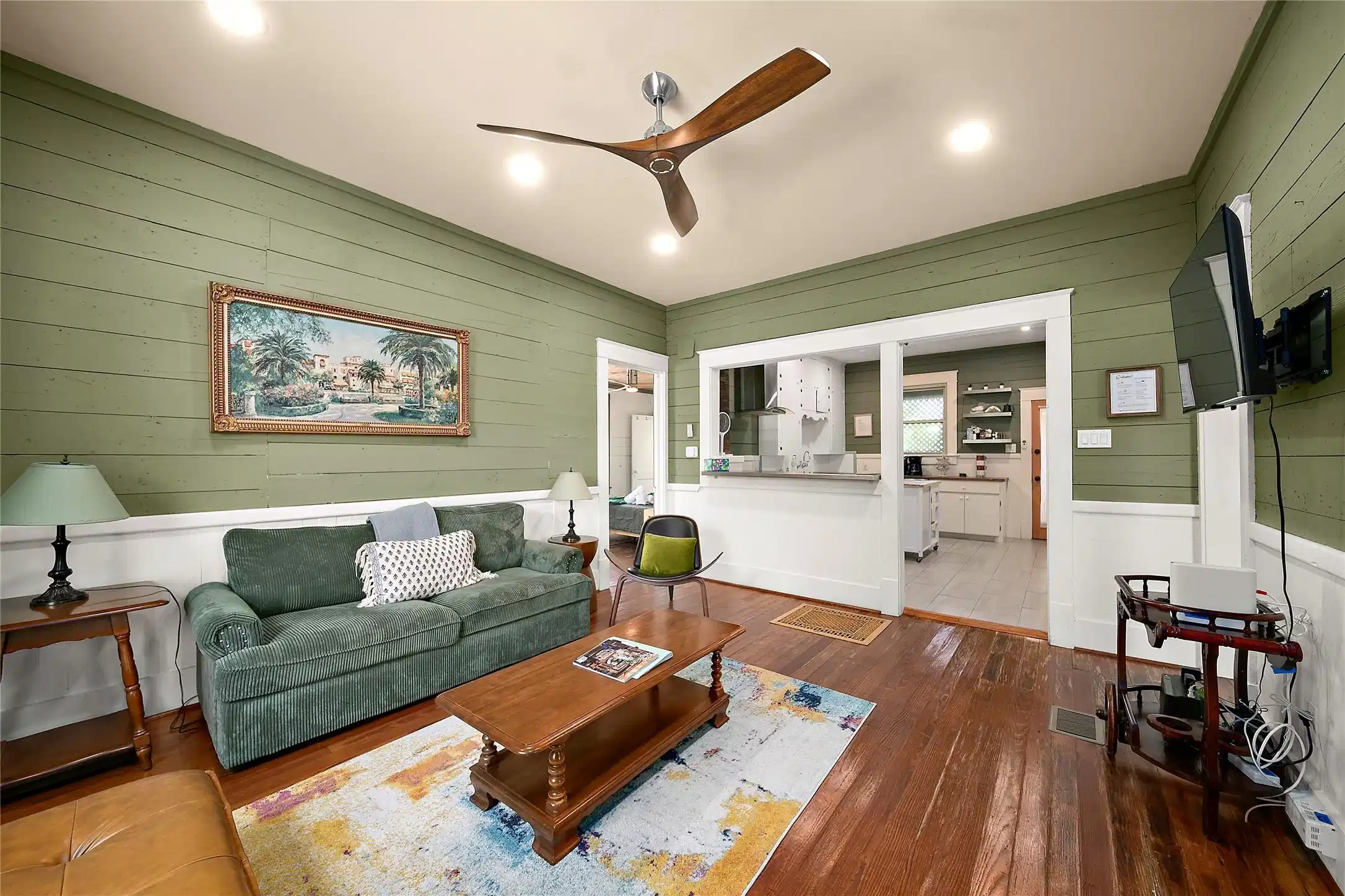 Image 1: Spacious living room with hardwood floors, high ce