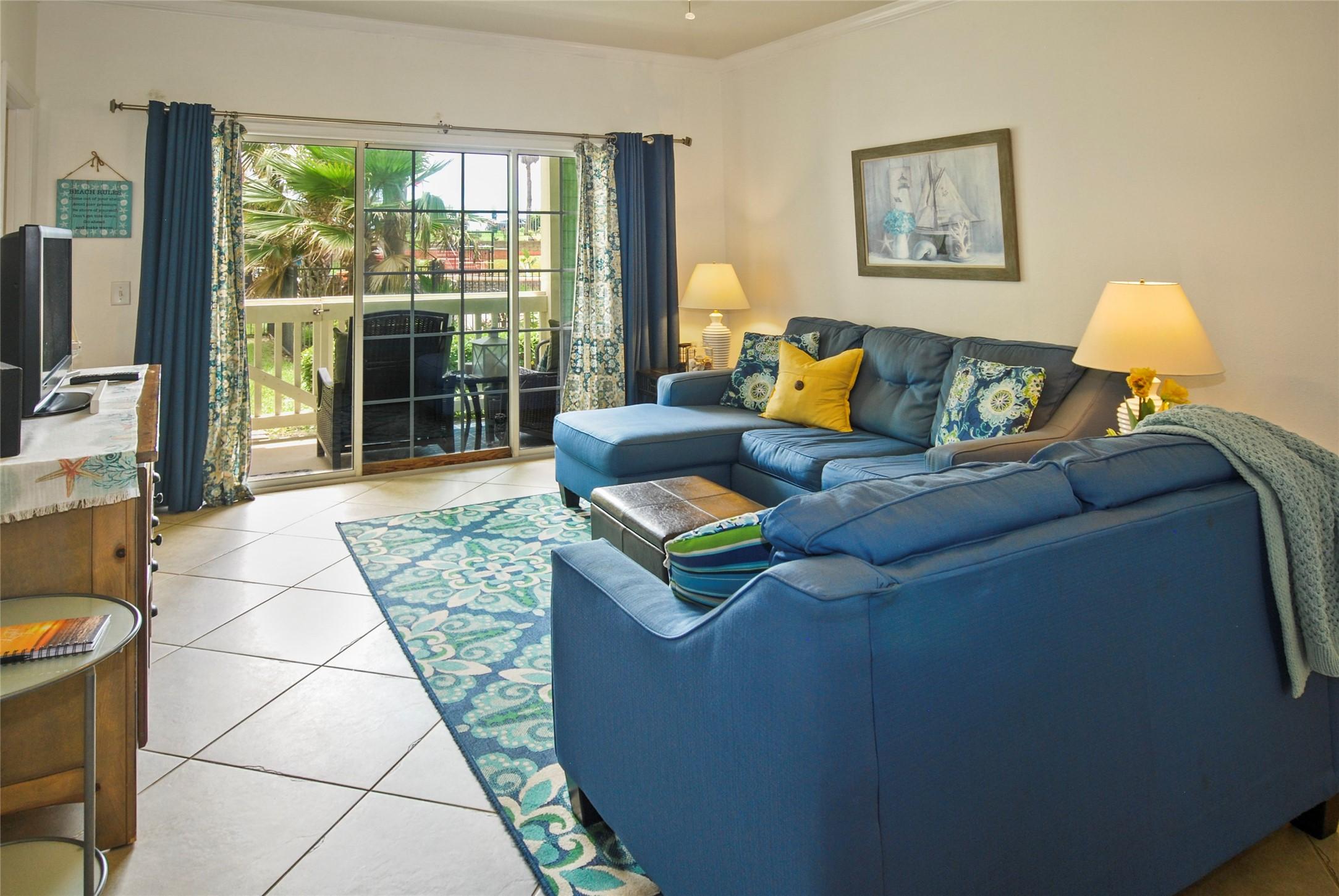 Image 2: Living room looks out to patio and front green spa