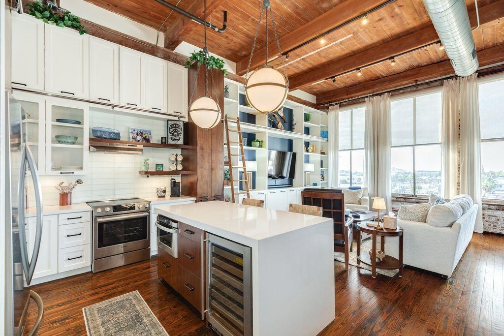 Image 3: Open concept kitchen and living area with exposed