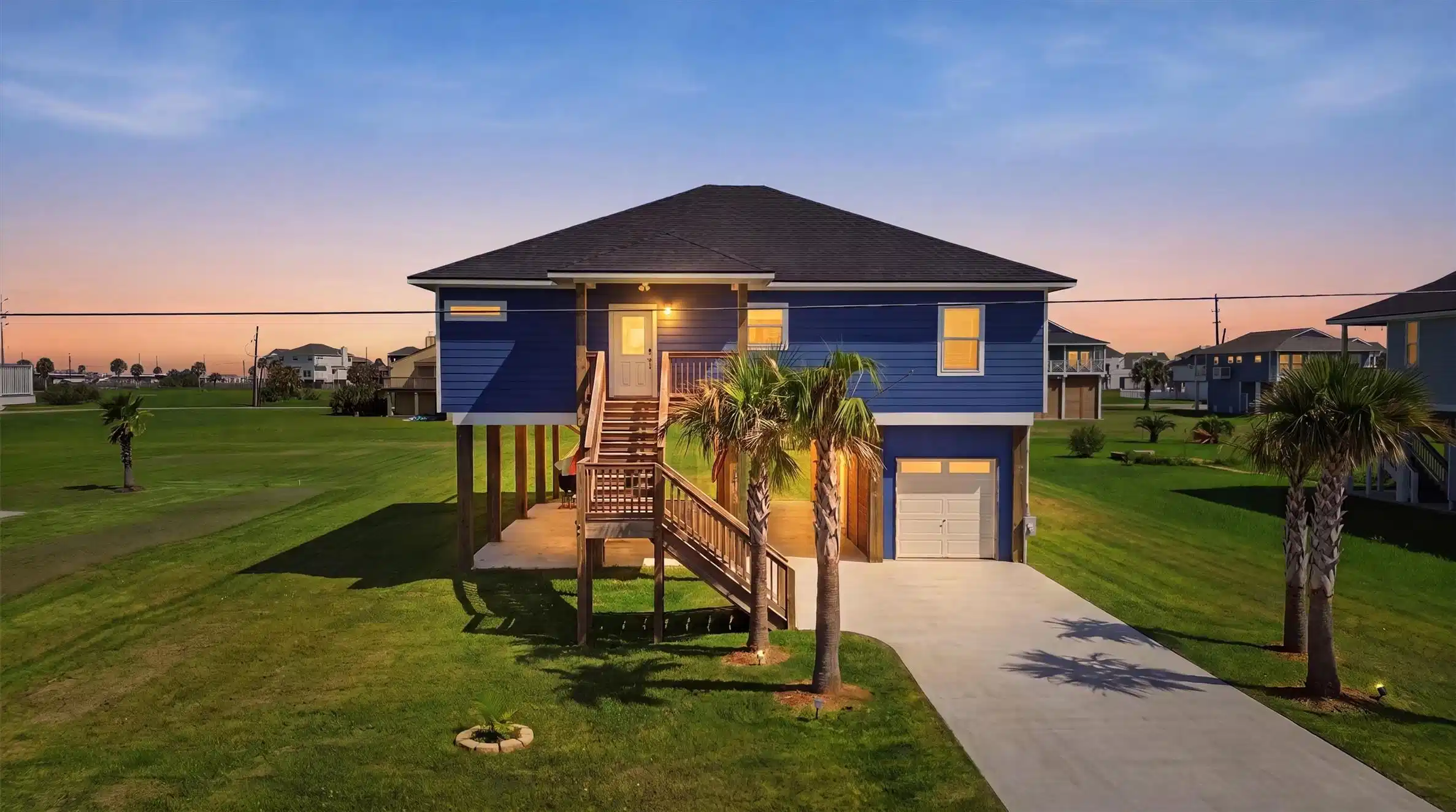 Image 1: Elevated coastal home with charming blue exterior.