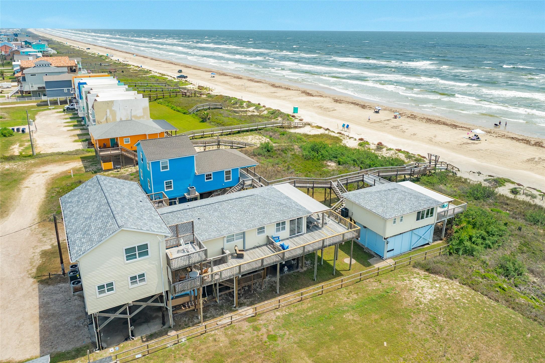 Image 1: Stunning beachfront aerial showcases the home's ex