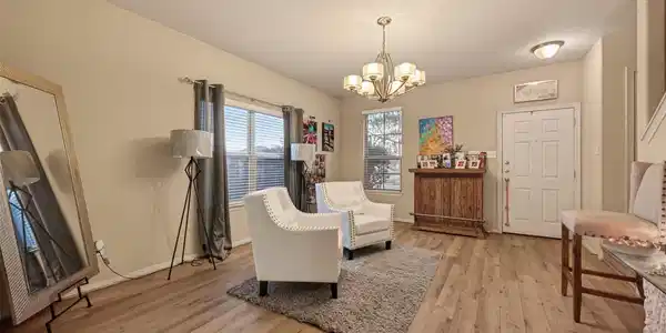 Image 2: Living area features hardwood floors, a stylish ch