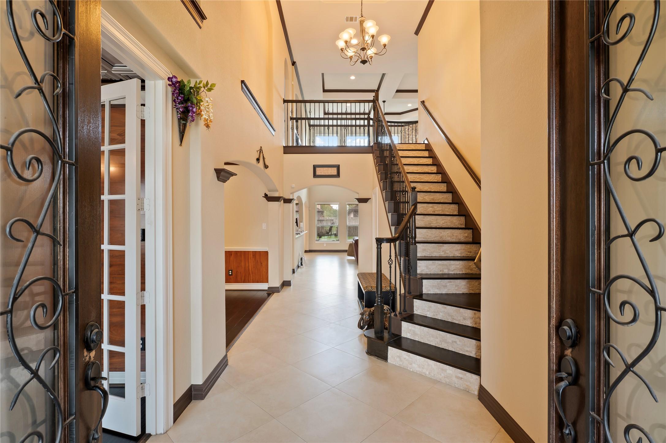 Image 4: Double front doors open up to the beautiful tiled
