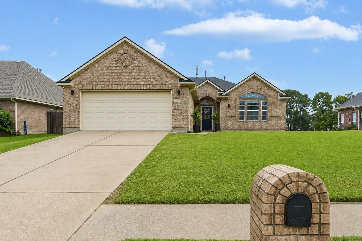 Image 1: Charming brick home with a spacious two-car garage