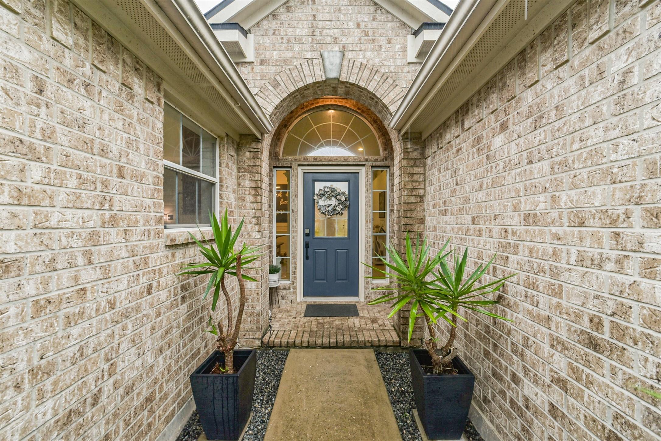 Image 2: Beautiful entrance with a welcoming blue door fram