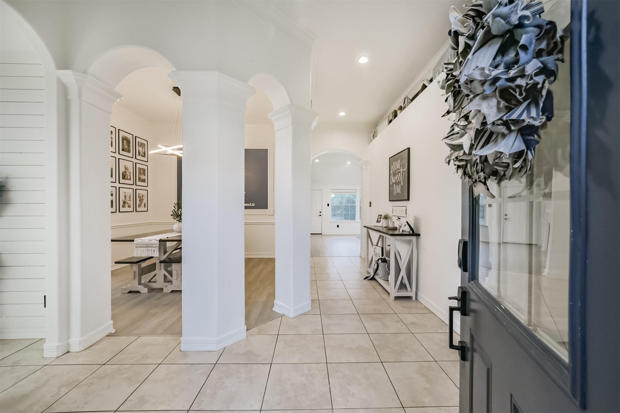 Image 3: Elegant entryway featuring arched doorways, tile f