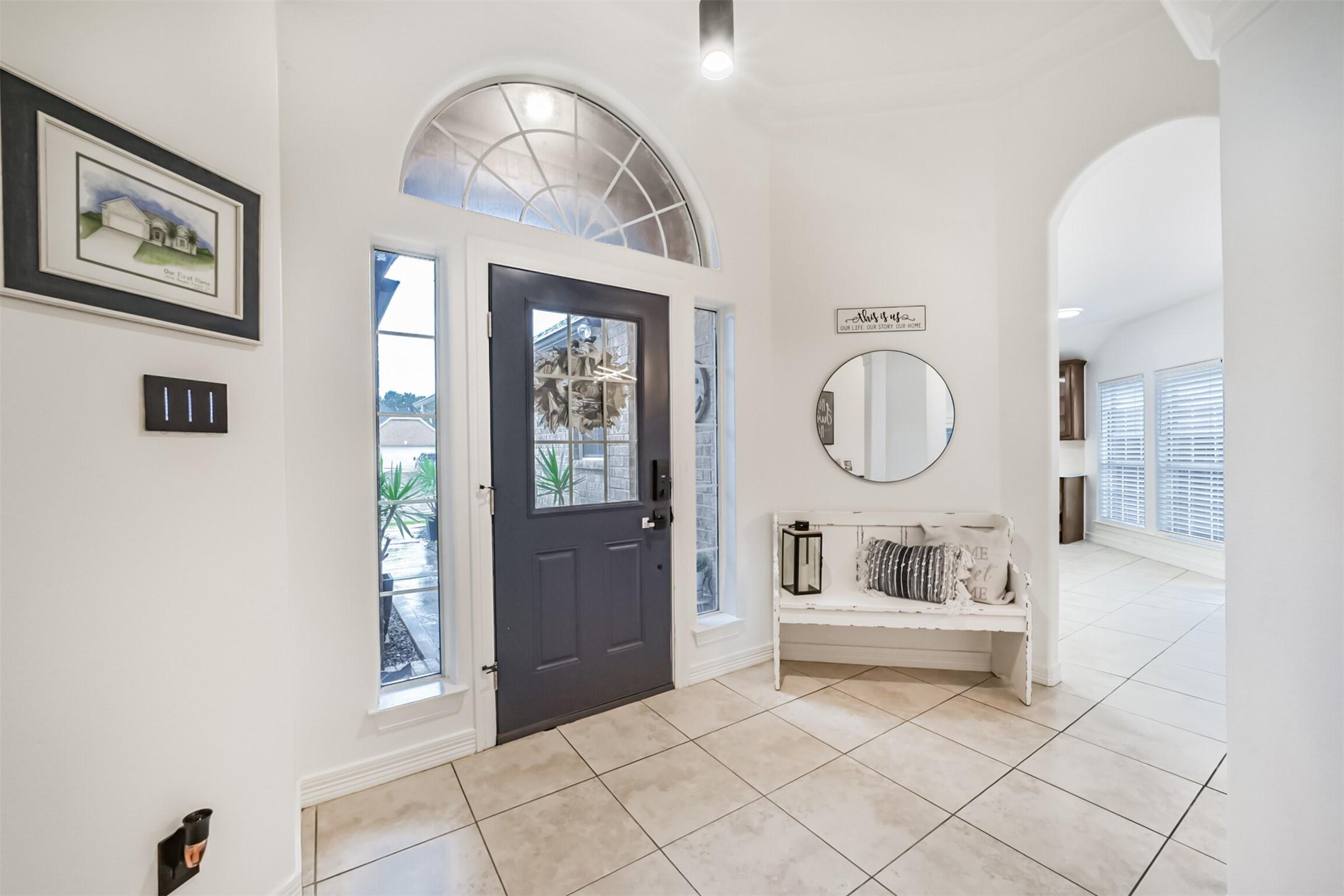 Image 4: Inviting entryway with a stylish dark door, arched