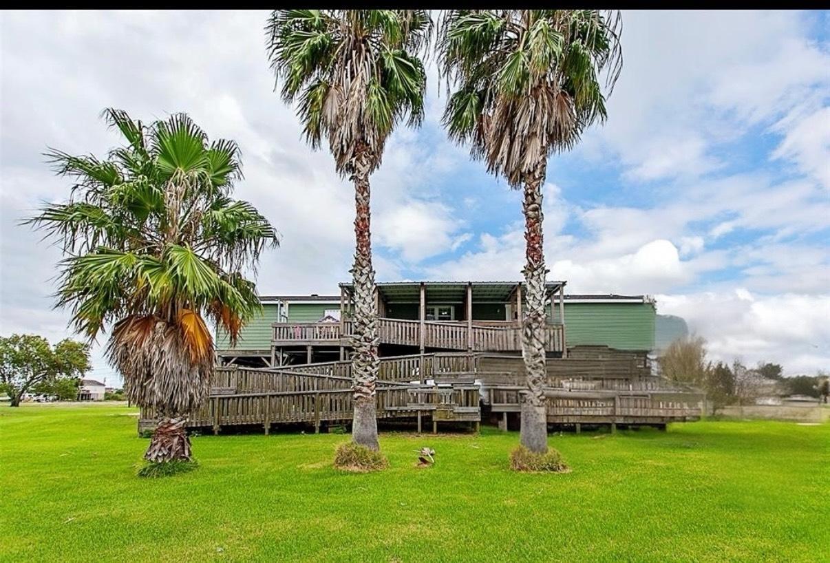 Image 2: Back view of the property featuring the wooden dec