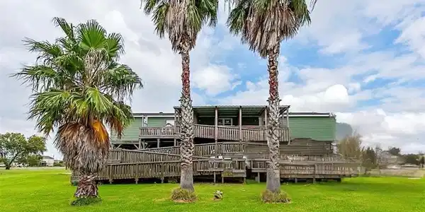 Image 2: Back view of the property featuring the wooden dec