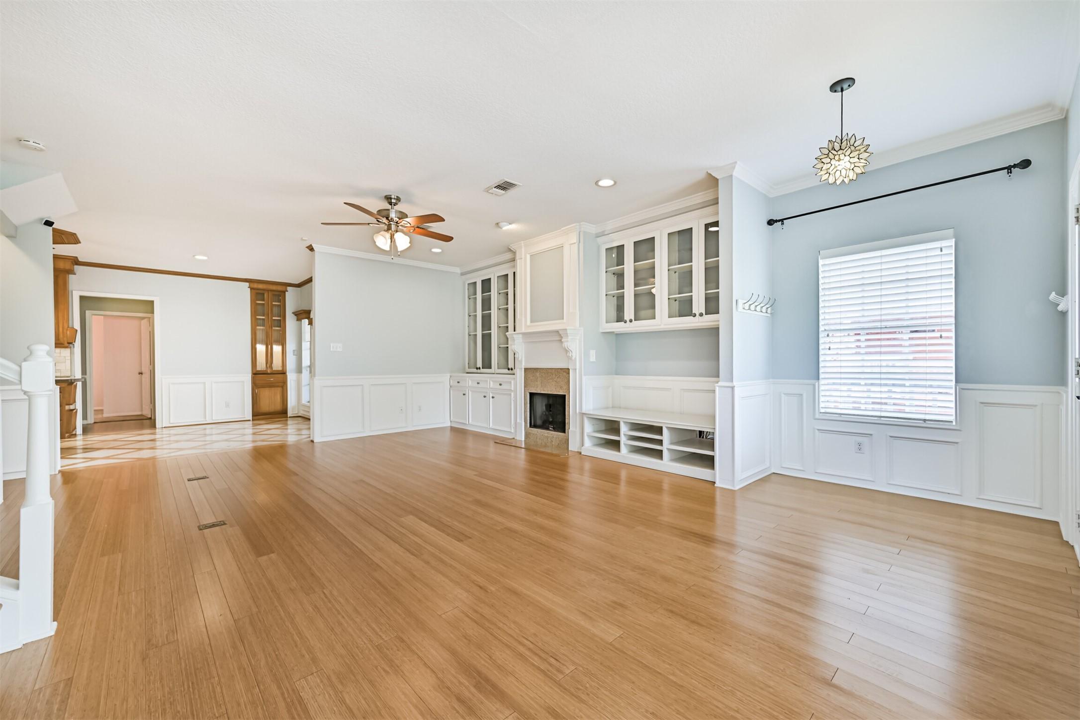 Image 4: This living area boasts wood flooring, built-in ca