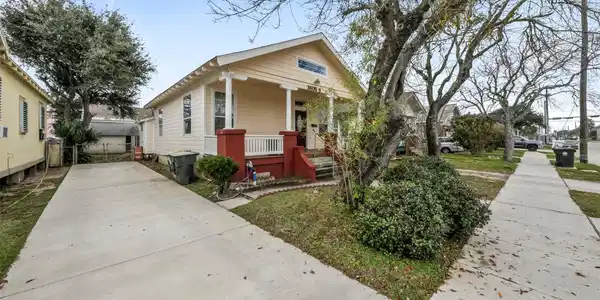 Image 2: Side view of home with a view of the driveway.