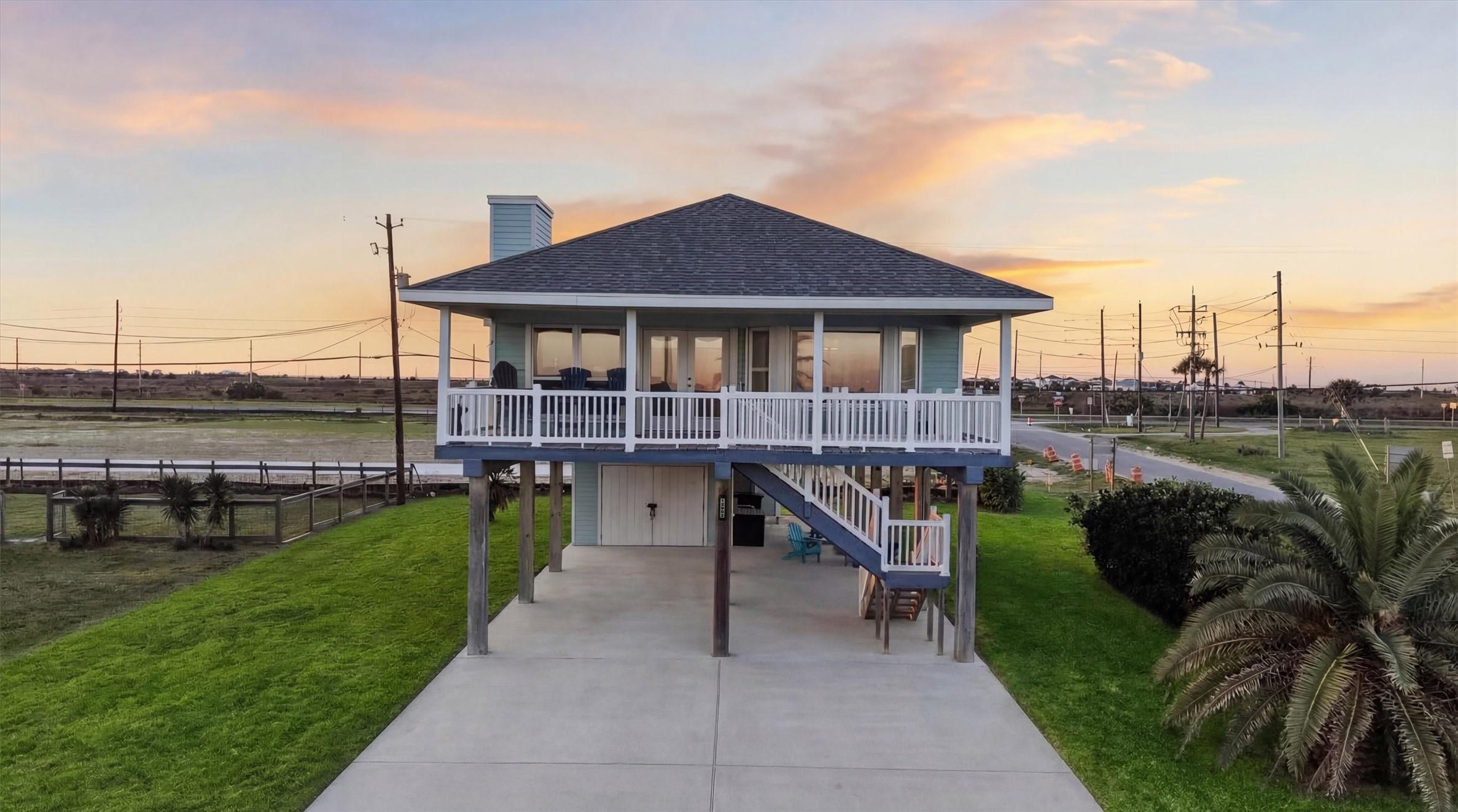 Image 2: Elevated coastal home with wraparound porch and co