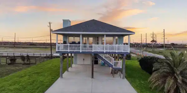 Image 2: Elevated coastal home with wraparound porch and co