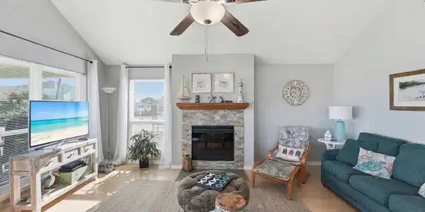 Image 3: Light-filled living area with vaulted ceilings, fi