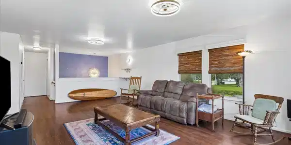 Image 3: Open living area with wood-style flooring and a se