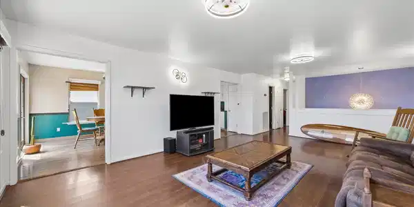 Image 4: Open-concept living area with wood-style flooring
