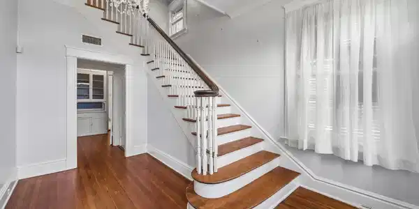 Image 3: Elegant entryway boasts a curved stairway with ban